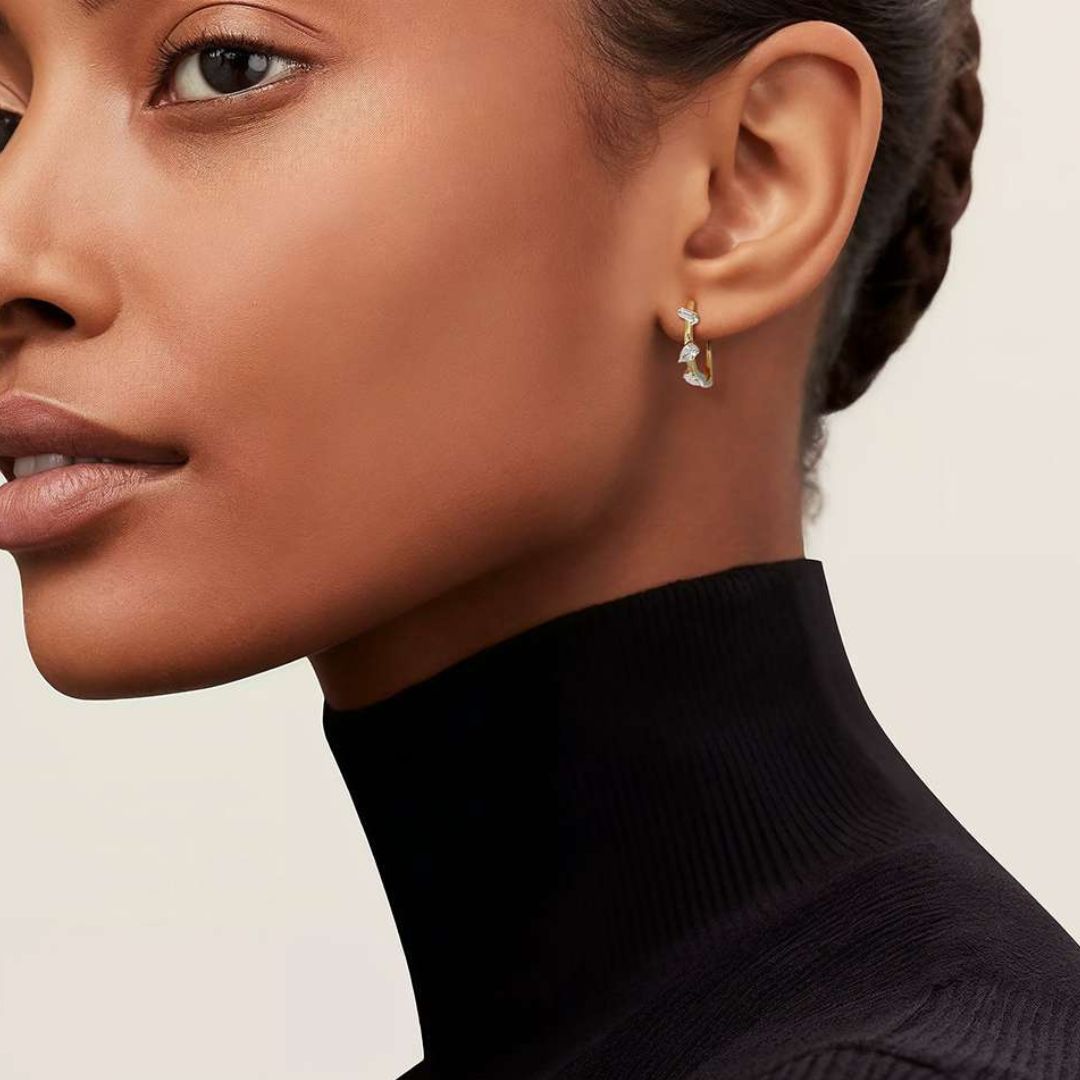 Discover timeless elegance with our Facet Fusion Diamond Hoop Earrings, featuring a captivating mix of marquise, pear, and baguette-shaped diamonds.

Meticulously crafted from sustainable materials, these hoops radiate brilliance, making them perfect for any occasion.

A true celebration of unique shapes and modern sophistication. On the model.