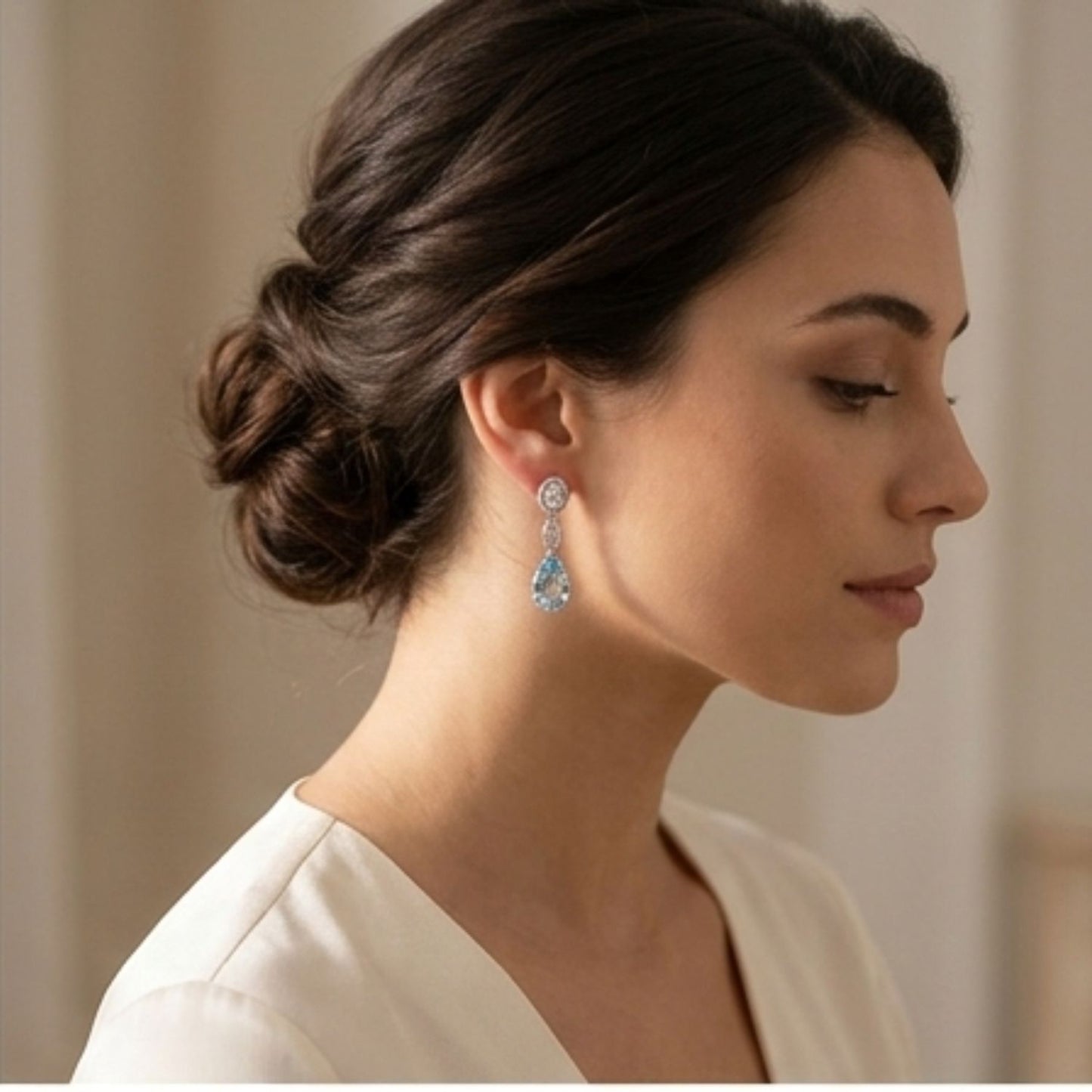 Pear-shaped aquamarine drop earrings in 18k white gold and yellow gold settings. On model