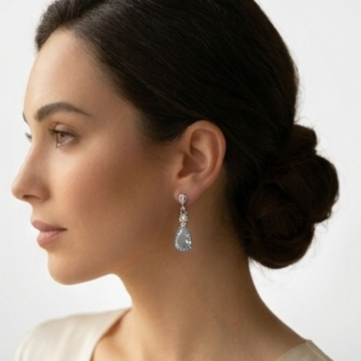 Pear-shaped aquamarine drop earrings in 18k white gold and yellow gold settings. on ear